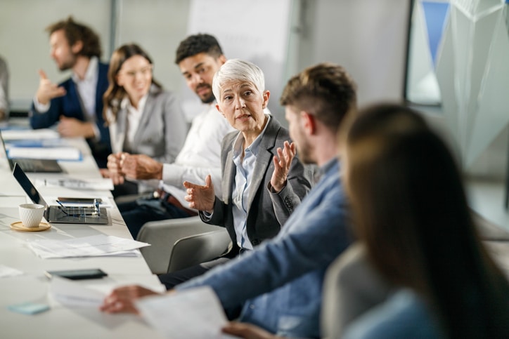Senior businesswoman talking to her colleagues in the office.